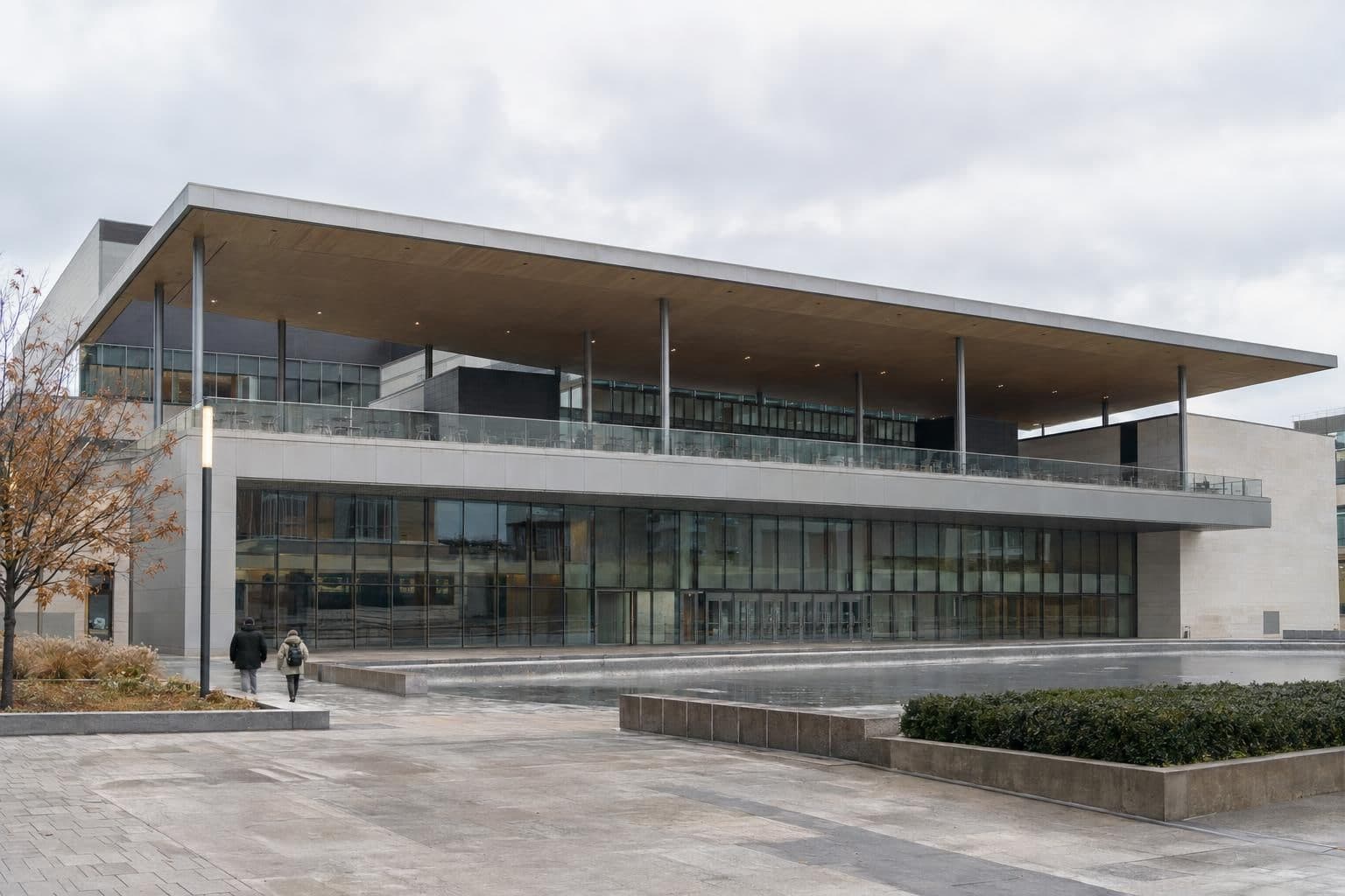 Exterior of a large modern performing arts center with a wide roof canopy on an overcast day