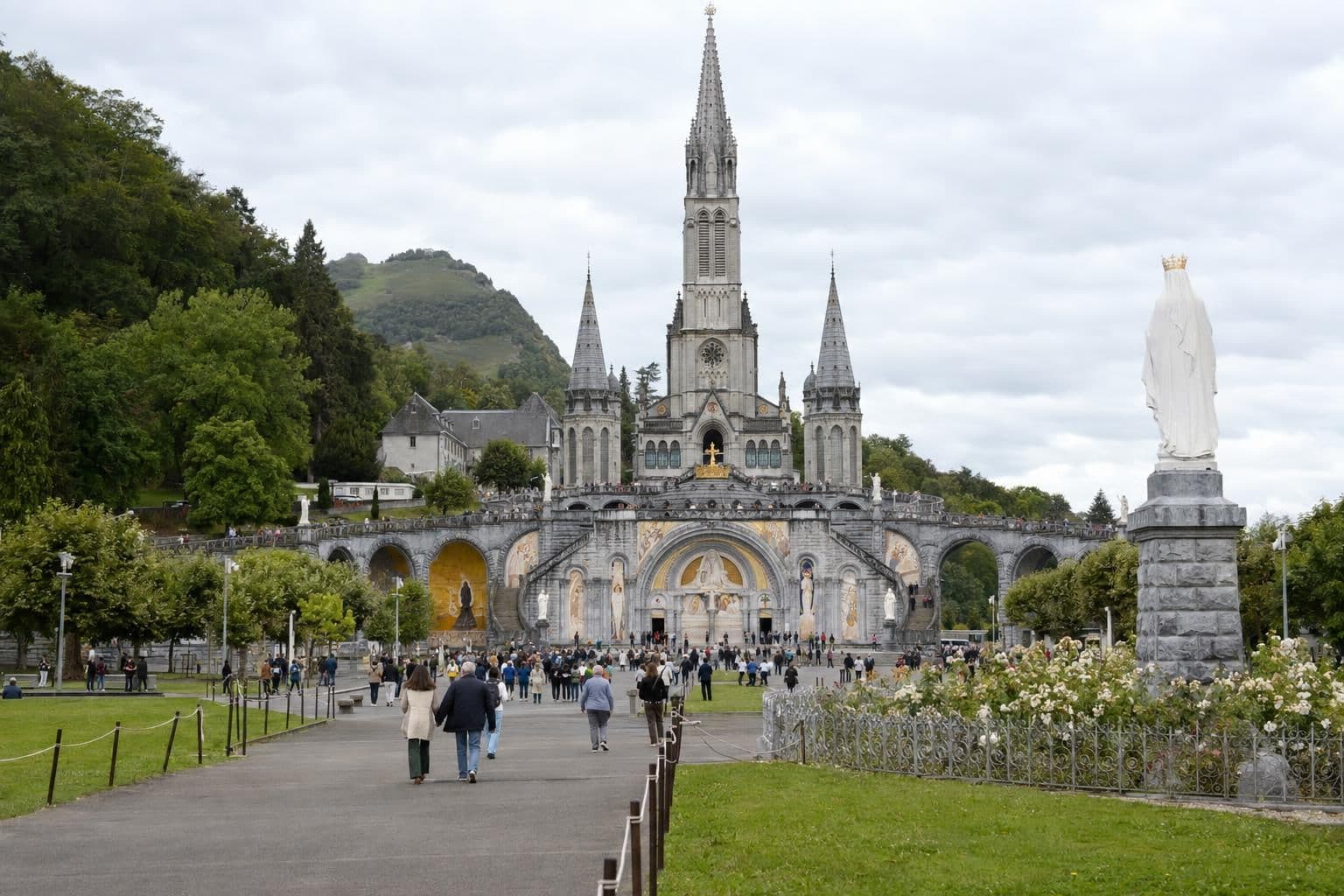 The church and grounds of the Catholic shrine at Lourdes, France, with pilgrims seen at a distance