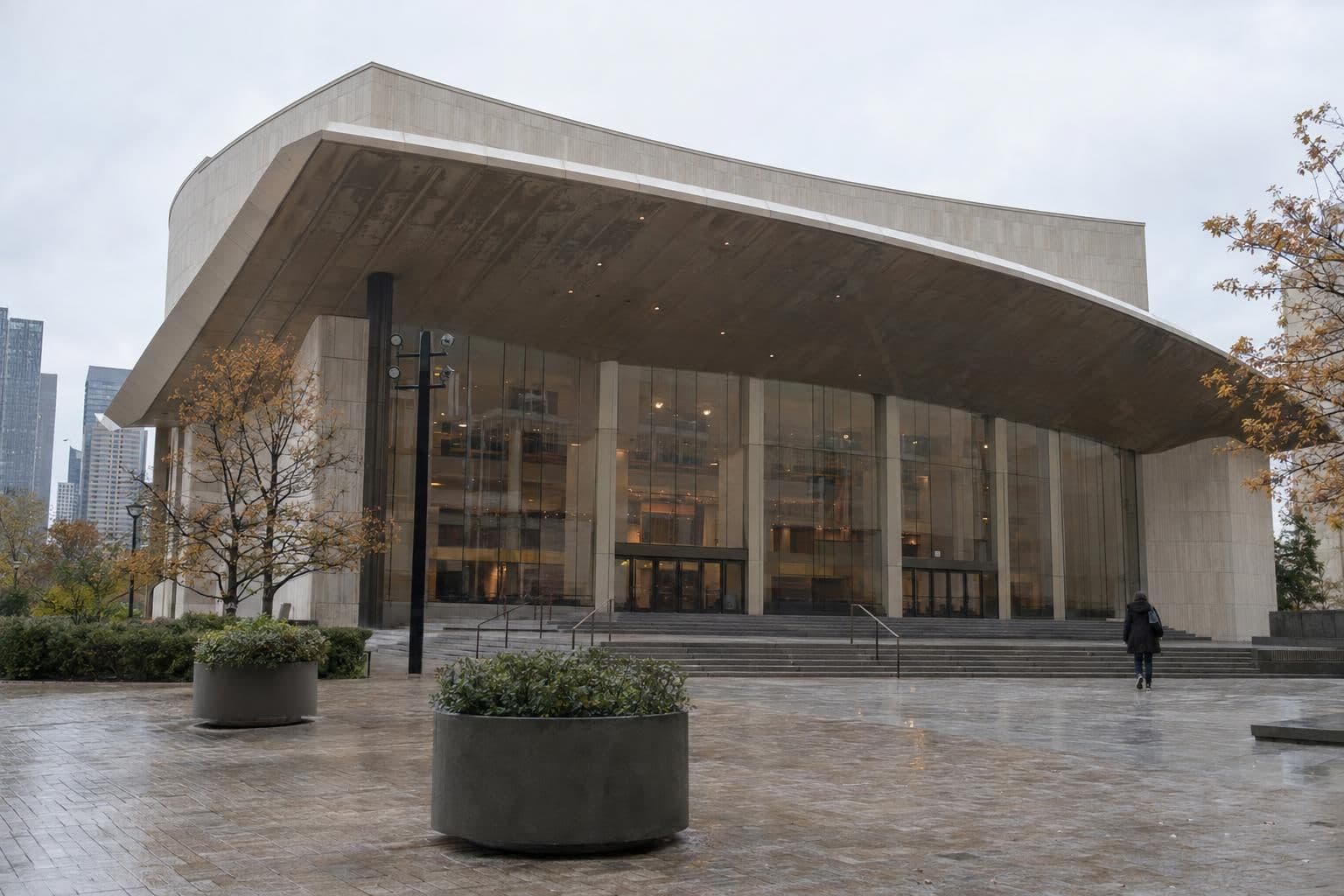 Exterior of a closed performing arts center building, showing its roof overhang and a quiet, empty entrance area