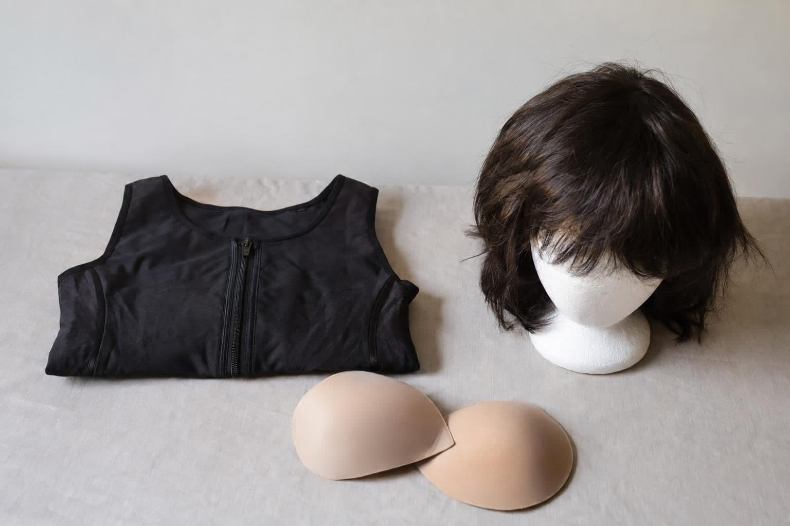 A chest binder, wig and breast padding, examples of social accommodations barred by the policy.