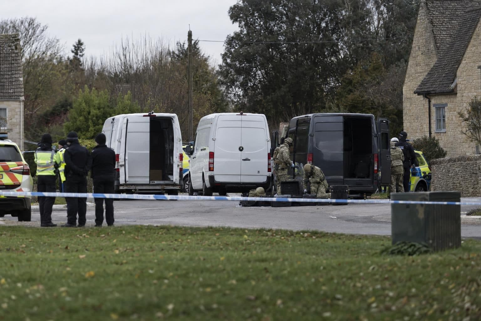 Three vans sit behind a police cordon as bomb-disposal specialists examine them near RAF Fairford.