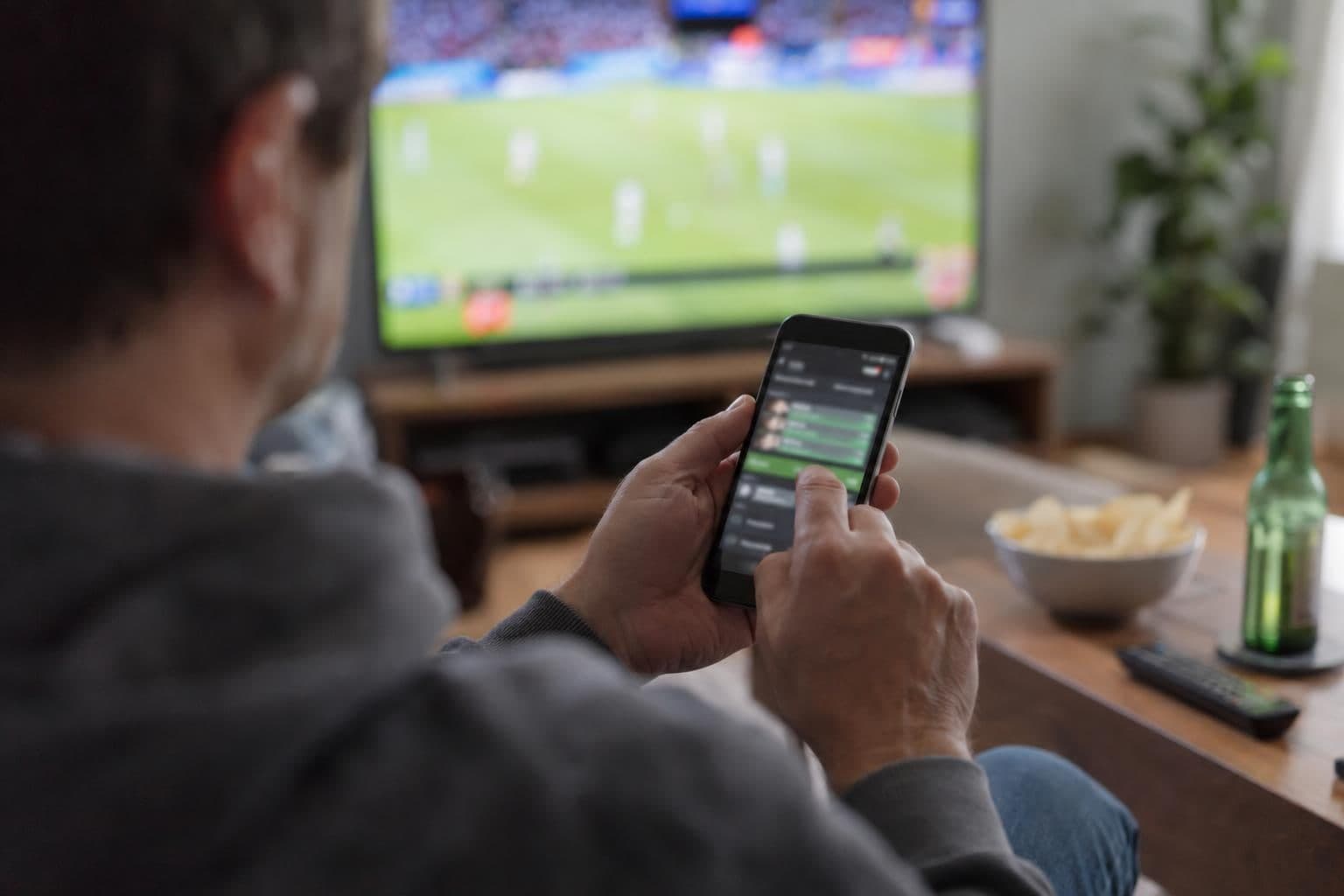A hand holds a smartphone with a generic interface for a sports-outcome wager.