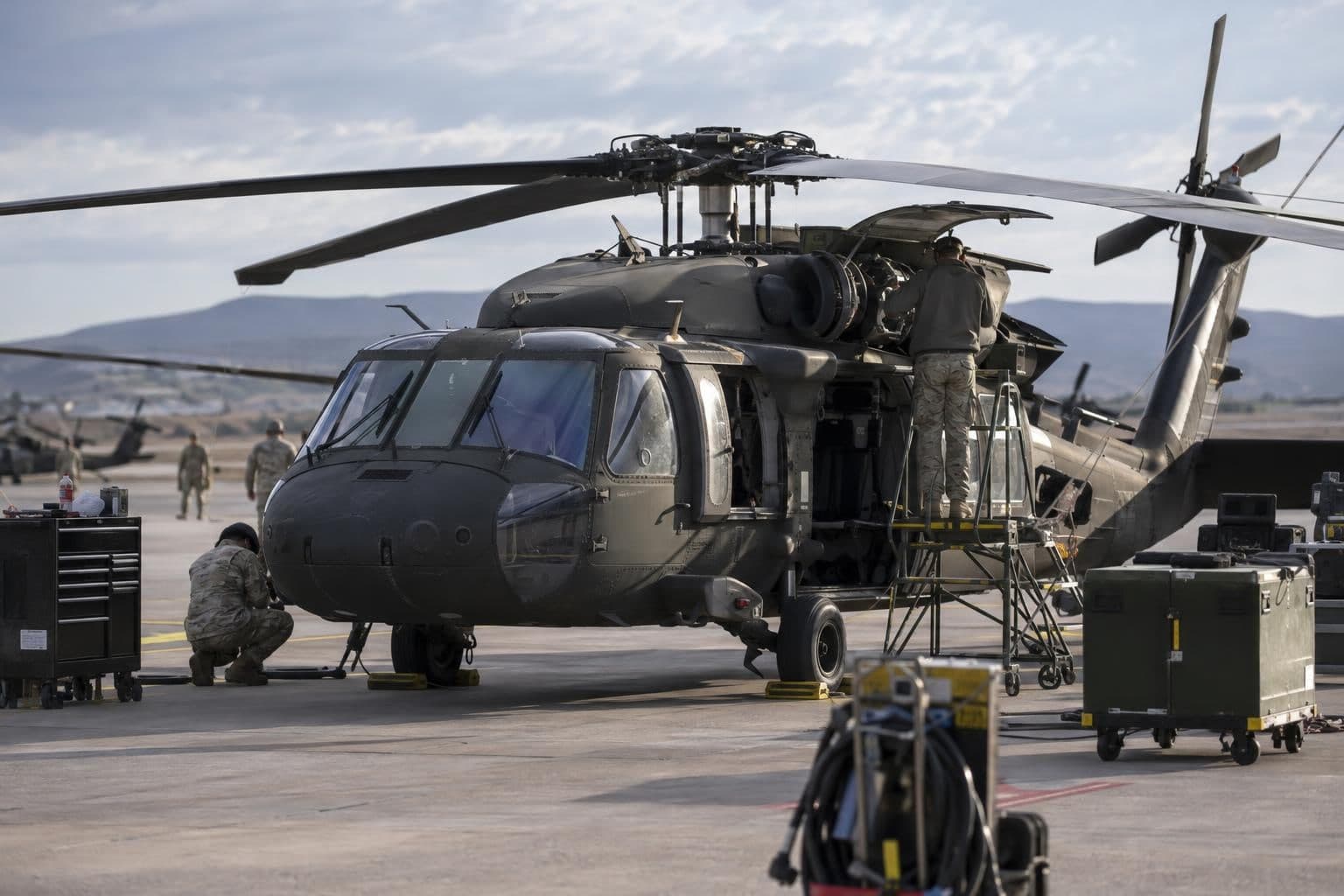 Maintenance personnel inspect an Army helicopter during fleet equipment checks.