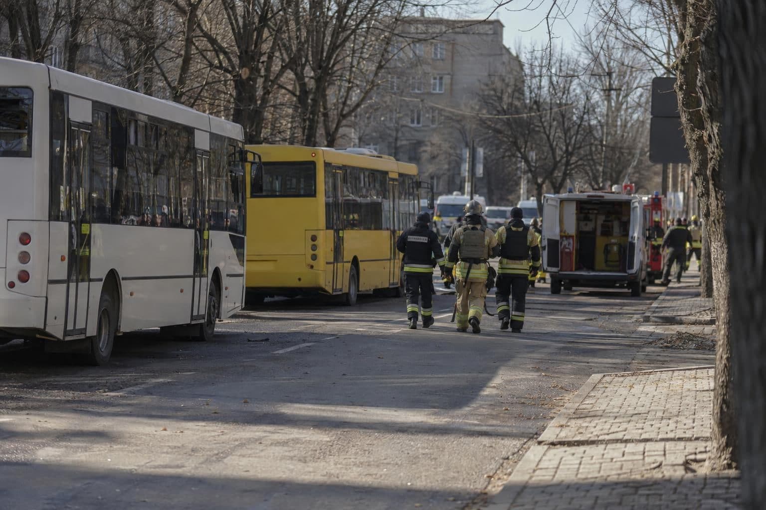 Emergency responders work near two public buses at a strike site in Kramatorsk.