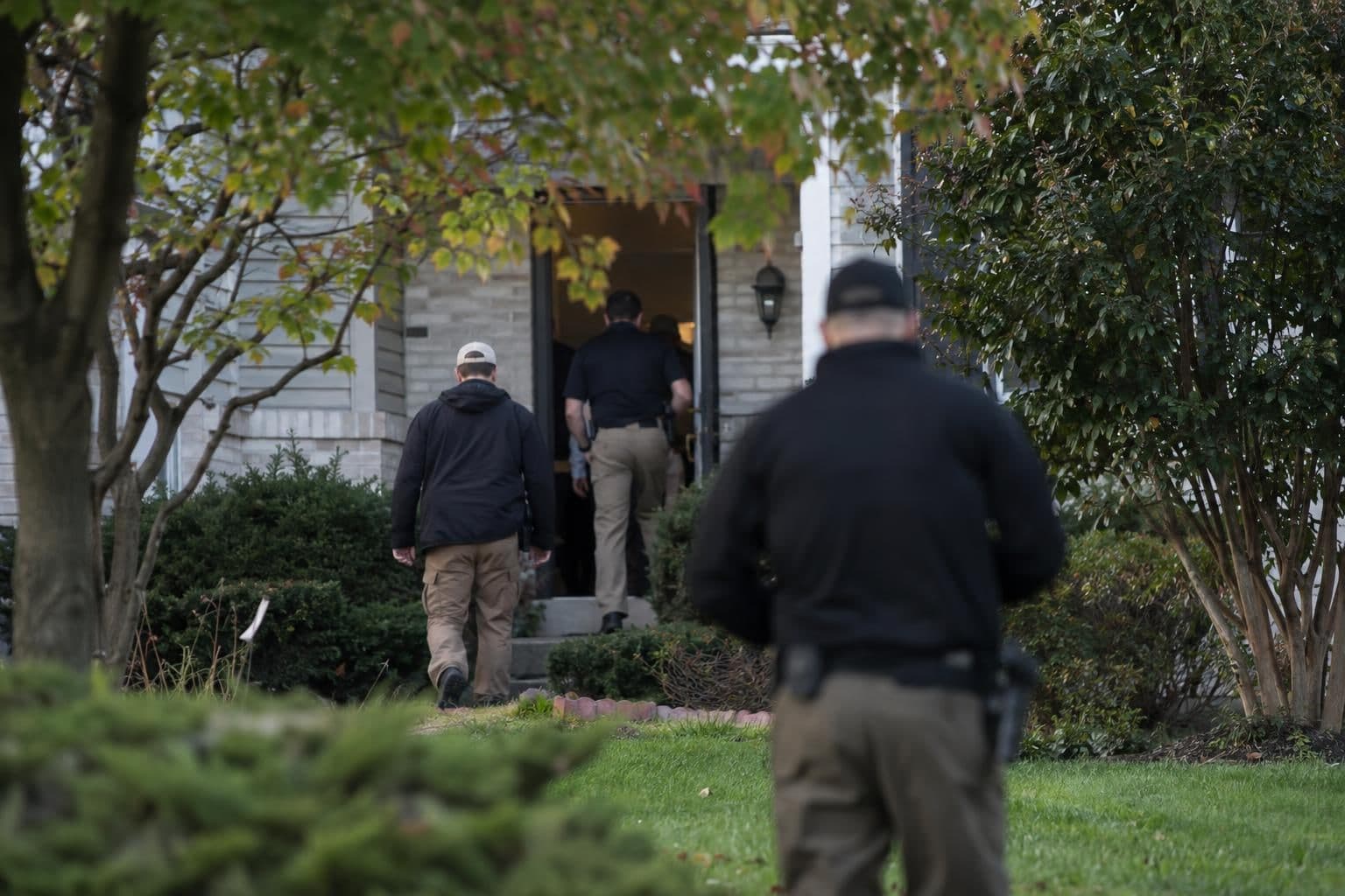 Federal investigators near a Washington-area home during a search