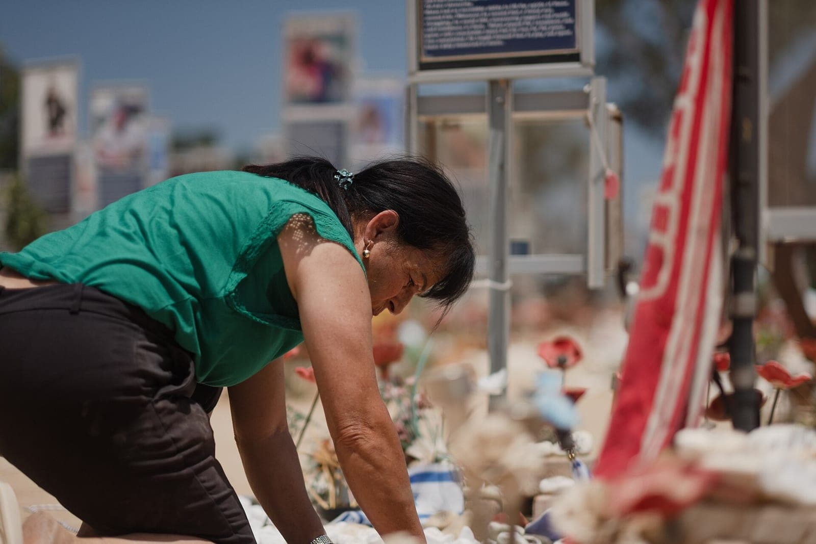 A grieving mother tends to a memorial to her son at the Nova Festival Memorial Site